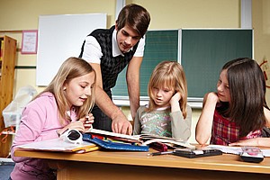 Lehrer mit Schulkindern im Klassenraum