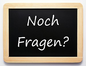 Tafel mit Aufschrift: Noch Fragen?