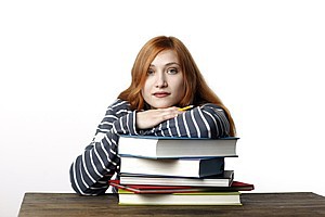 Erwachsene Schülerin stützt sich auf Schulbücher